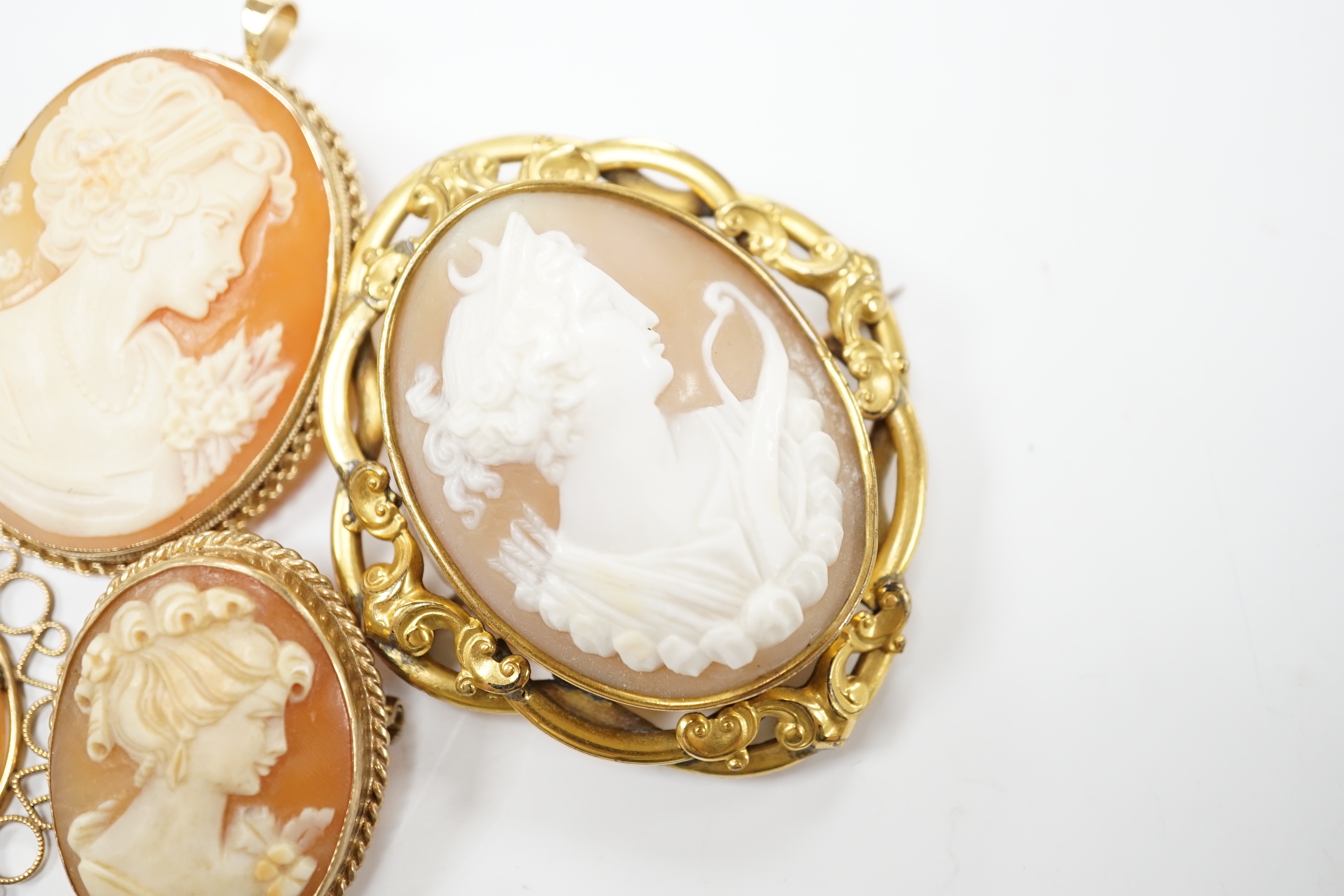 Two modern 9ct gold mounted oval cameo shell pendant brooches, largest 42cm and two other mounted oval cameo shell pendant or brooches and a mourning brooch (a,f,).